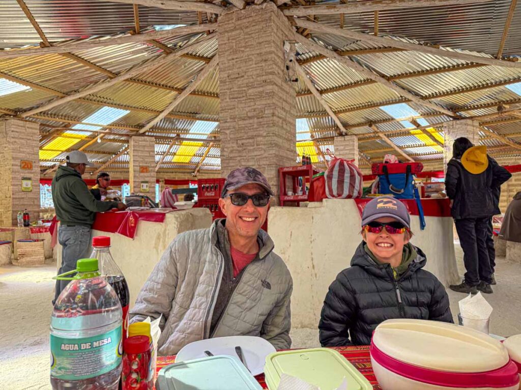 Dan Brewer, owner of the Family Can Travel blog, enjoys lunch with his son at the original salt hotel in the Uyuni Salt Flats in Bolivia.