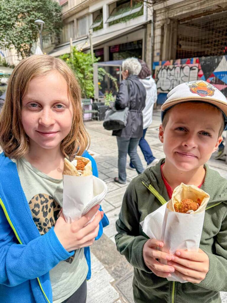 Two kids eat wraps from Falafellas - a kid-friendly restaurant in Athens, Greece.