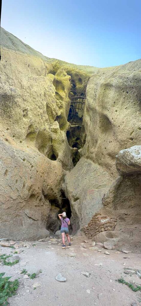 Celine Brewer looking up at the Monk's Prison while hiking around Meteora with her kids.