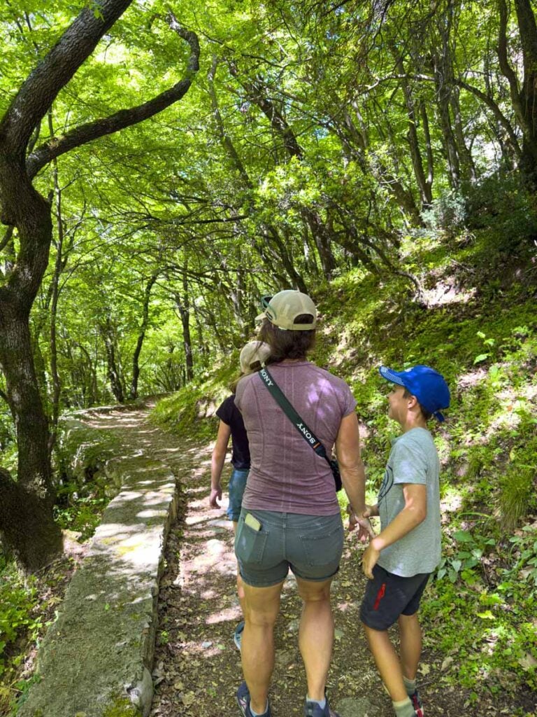 Celine Brewer, of the FamilyCanTravel.com blog, hikes through a magical forest with her kids in Meteora, Greece.