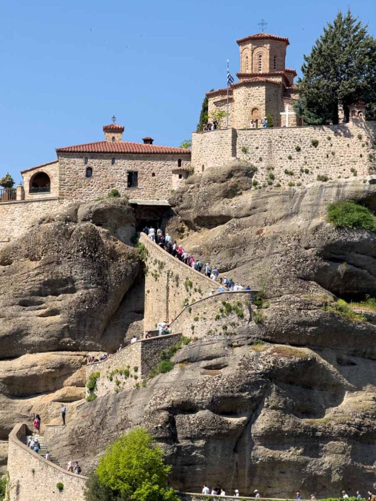 a long line of people wait to get into the Varlaam Monastery in Meteora, Greece.