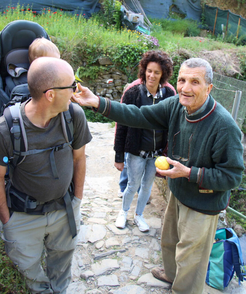 An Italian lemon farmer in Cinque Terre shares freshly cut lemons with the Brewer kids while on a family hike.
