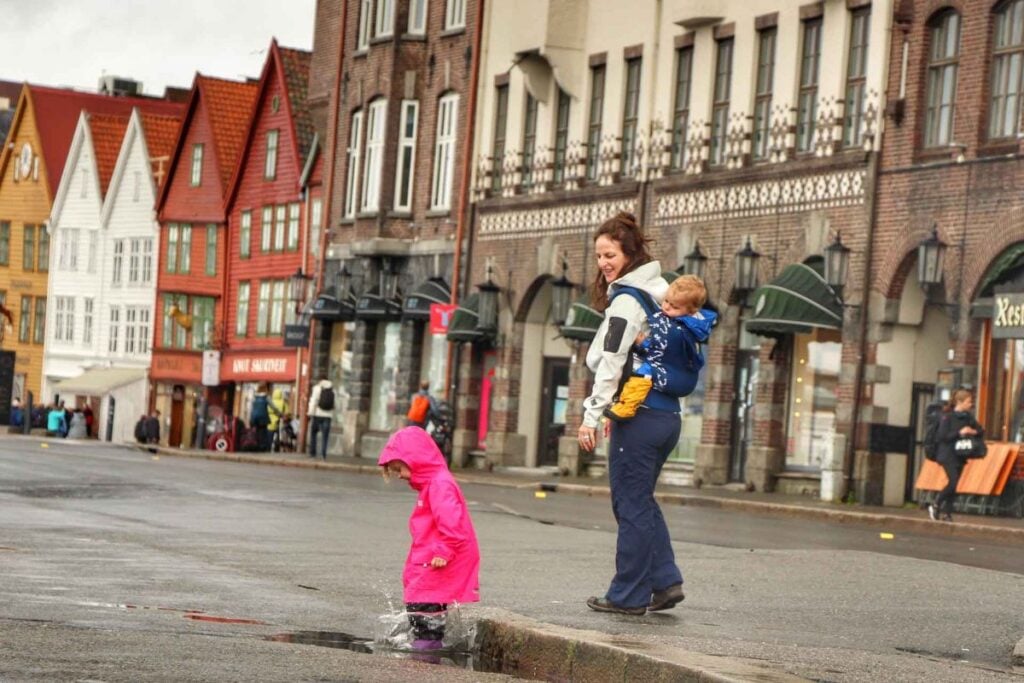 Celine Brewer, owner of FamilyCanTravel.com, watches her daughter play in a puddle in the Bryggen district of Bergen, Norway.