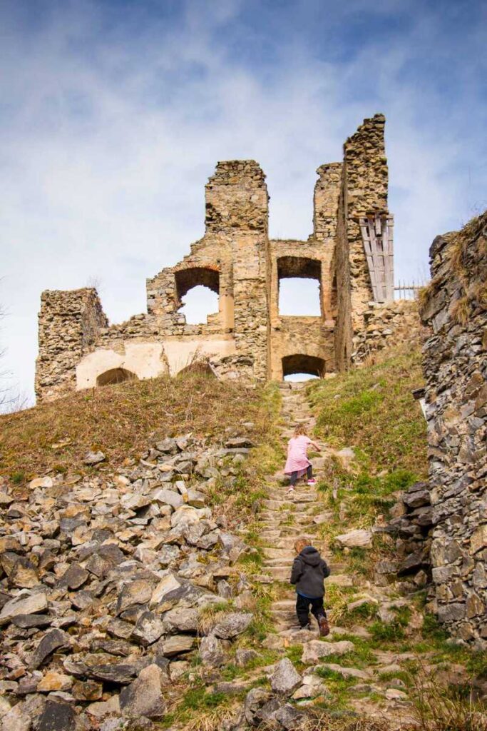 a 4-year old girl climbs a hill near the Divci Kamen castle ruins near Cesky Krumlov.