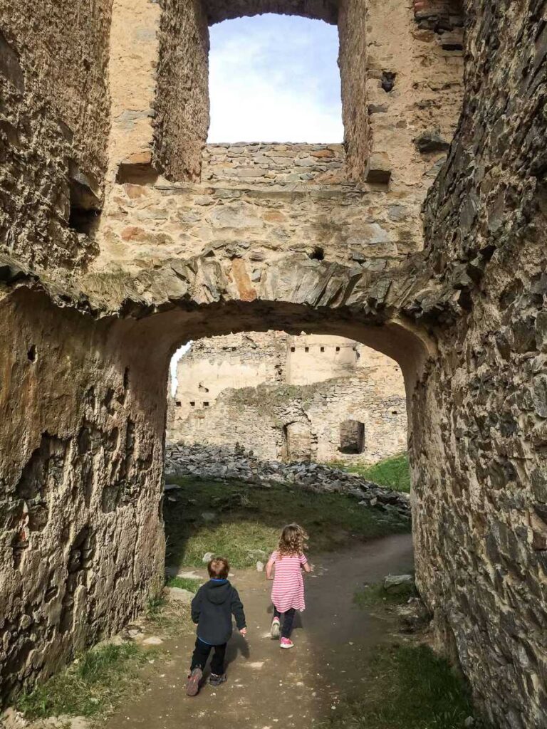 Two children explore the Divci Kamen castle ruins.