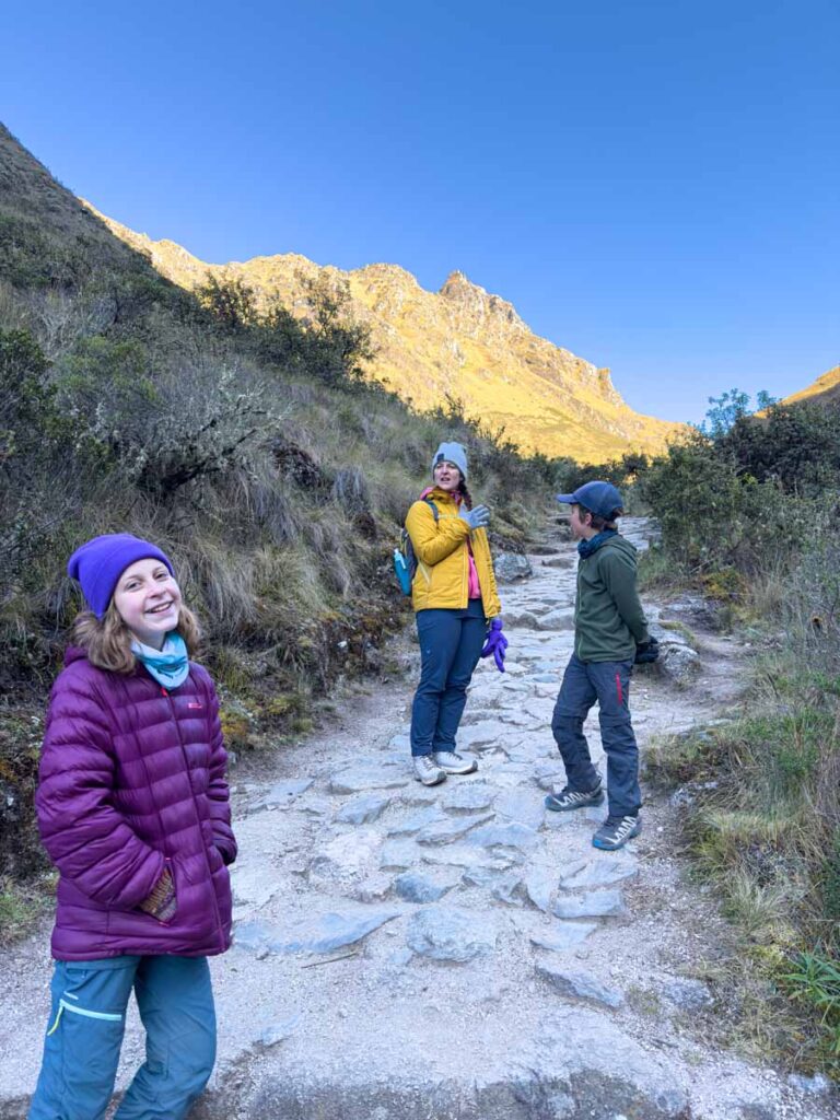 an 11-year old girl is all smiles while hiking up Dead Woman's Pass while hiking the Inca Trail with her family.