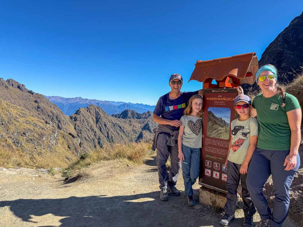 Dan and Celine Brewer, owners of the Family Can Travel blog, celebrate reaching the summit of Dead Woman's Pass on the Inca Trail with their kids.