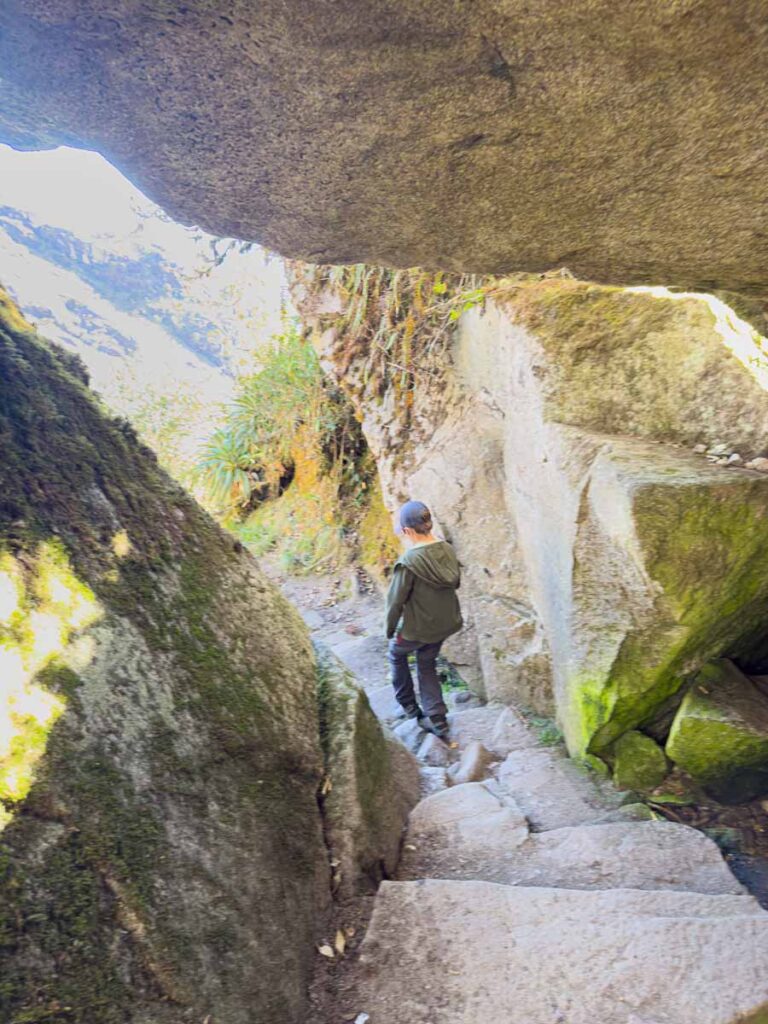 A 9-year old boy hikes through a cave on the final descent of day 2 on the Inca Trail.