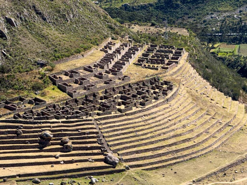 The Llactapata Inca ruin, seen from the Inca Trail, features many stone buildings and agricultural terraces.
