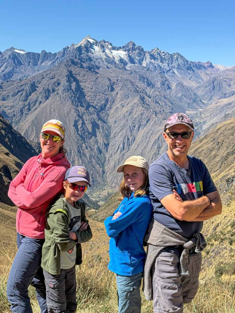 Dan and Celine Brewer, from the Family Can Travel blog, pose for family pictures on top of Dead Woman's Pass while on a family-friendly hiking tour on the Inca Trail in Peru.