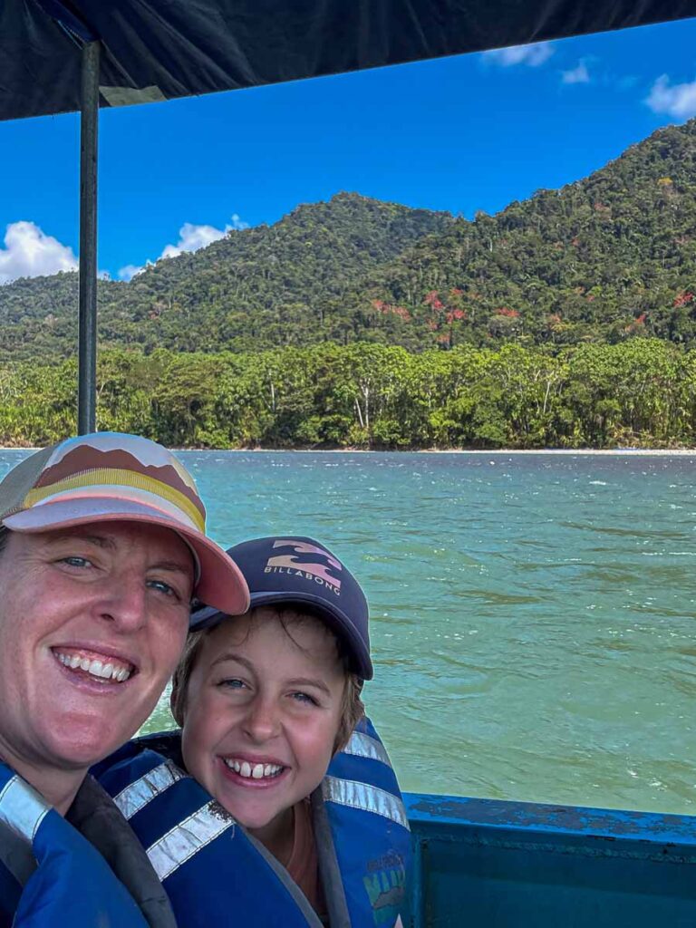 Celine Brewer, owner of FamilyCanTravel.com, and her son enjoy the jungle scenery on a boat heading towards Manu National Park in Peru.