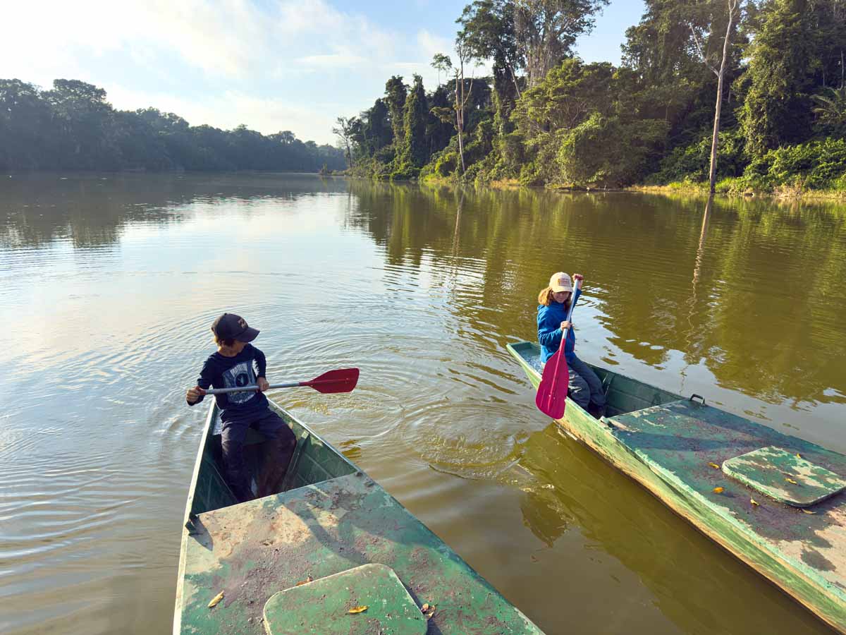 The Brewer kids, from the FamilyCanTravel.om blog, try paddling the catamaran on Salvador Lake in Manu National Park, Peru.