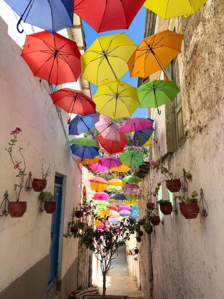 colorful umbrellas line a road in Paucartambo, Peru.