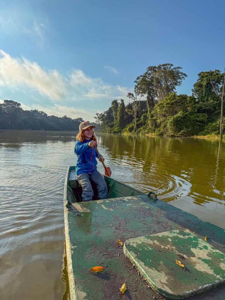 a 12-year old girl is all smiles as she takes a turn paddling the catamaran on Salvador Lake in Manu National Park.