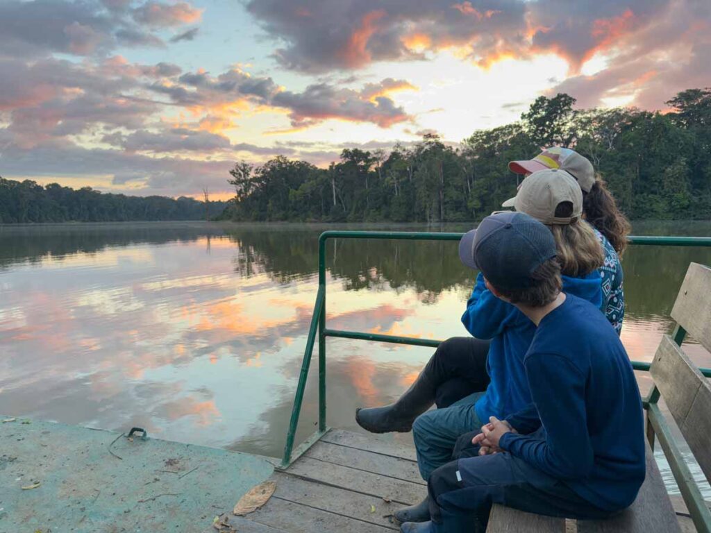 The Brewer family, from the FamilyCanTravel.com blog, looks for wildlife on Salvador Lake at sunrise in Manu National Park.