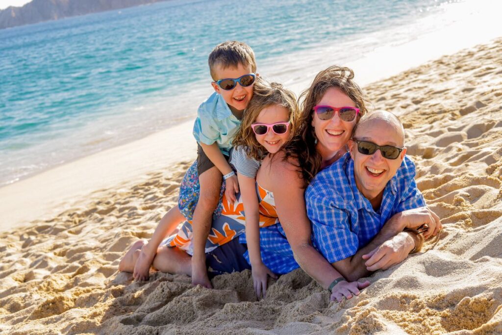 Dan and Celine Brewer, owners of FamilyCanTravel.com, play on the beach while on a family trip to Mexico with kids in Cabo San Lucas.