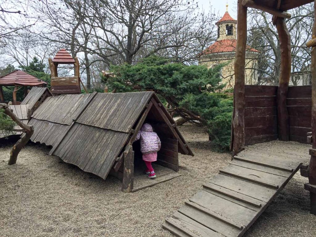 a 4-year old girl plays in a wooden playground near Vysehrad Fortress in Prague.