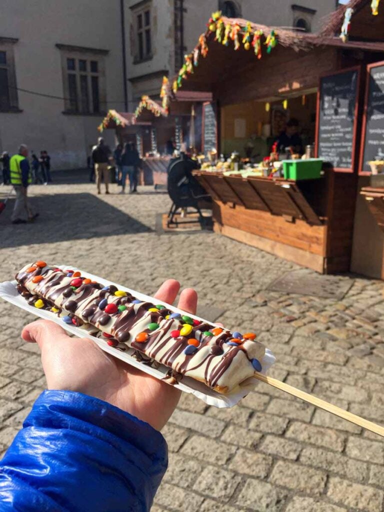 Celine Brewer holds a chocolate covered waffle outside the Prague Castle.