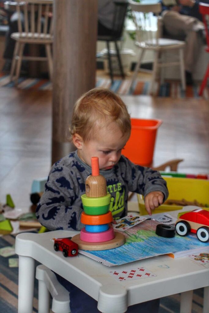 a 2-year old boy plays with toys in the play area on the Hurtigruten voyage from Alesund to Geiranger.