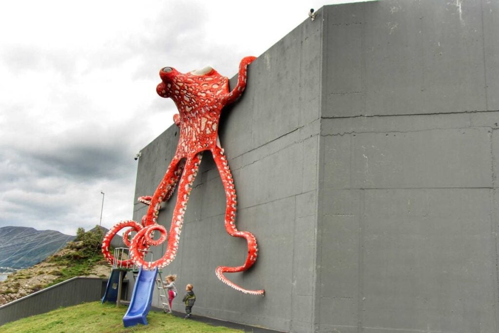 a giant octopus hovers over a small playground at the The Atlantic Sea Park - one of the top kid-friendly attractions in Alesund, Norway.
