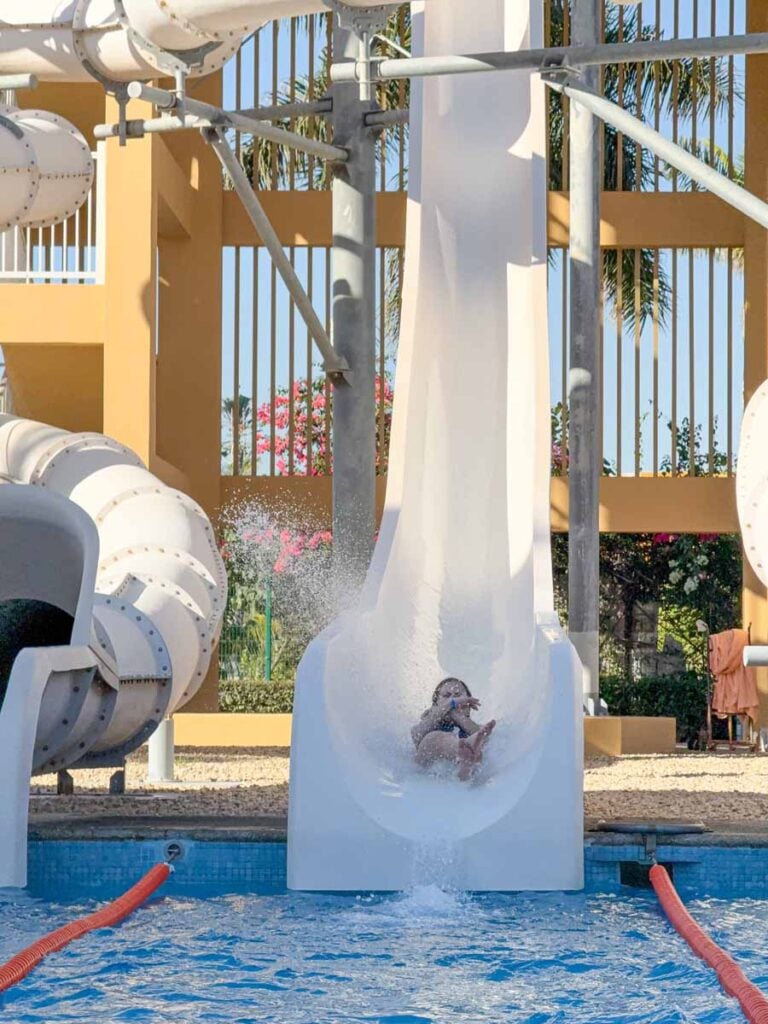 a 12-year old girl races down a steep waterslide at the water park at the Riu Palace Cabo San Lucas resort.