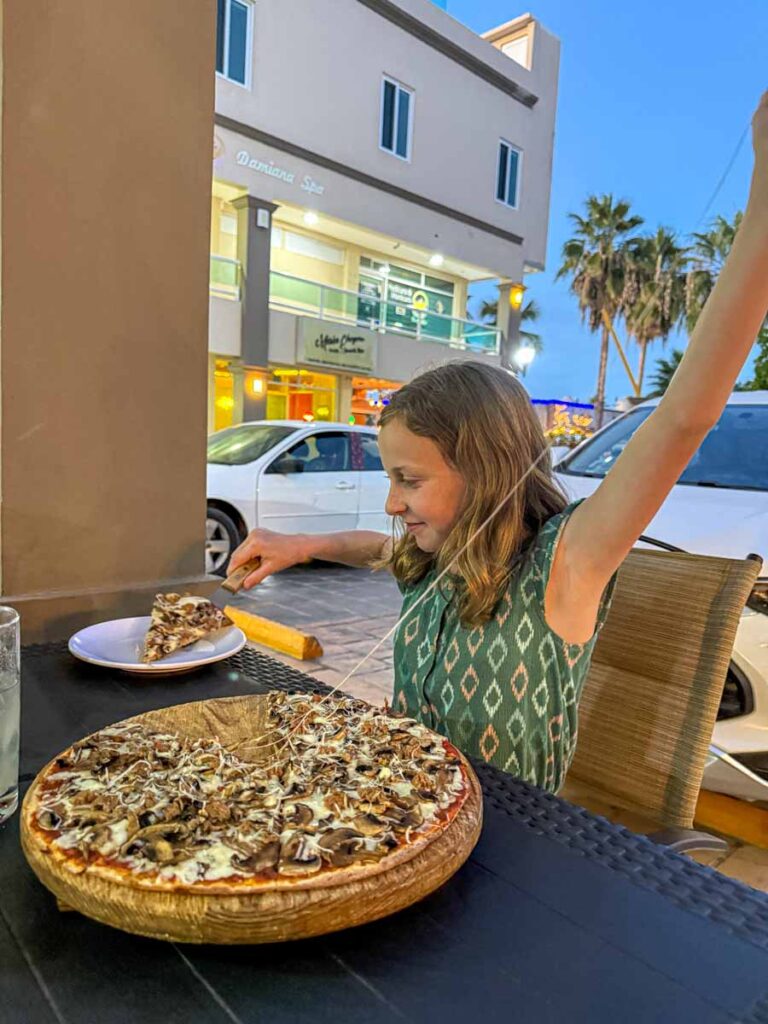 a 12-year old girl on vacation in La Paz, Mexico enjoys a pizza at Sofia Pizza Restaurant Bar.
