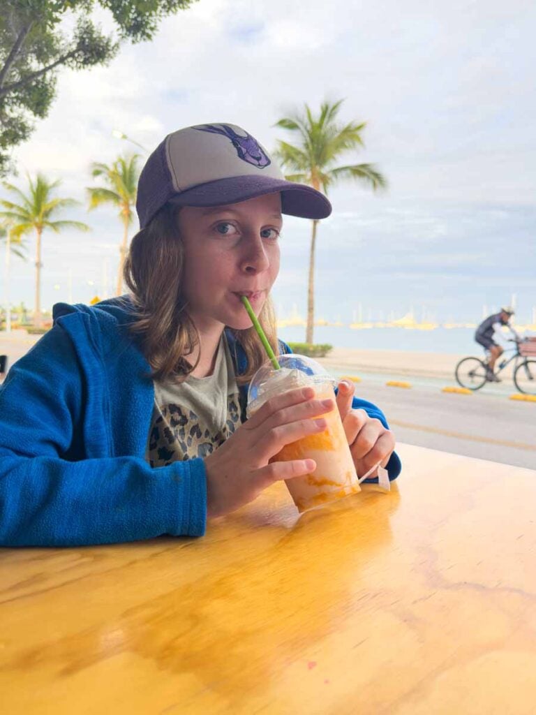 a 12-year old girl drinks a mango smoothie at CinaRoll while on a family vacation to La Paz, Mexico.