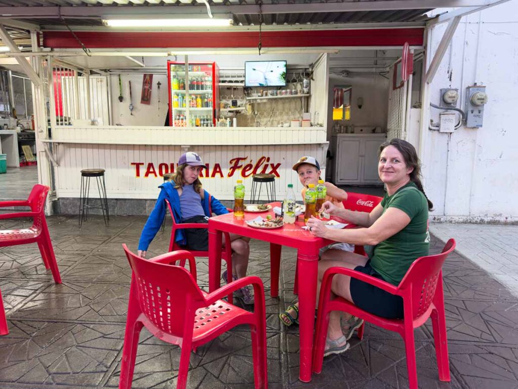 Celine Brewer, owner of the Family Can Travel blog, enjoys a family taco feast at Taqueria Felix in La Paz, Mexico.