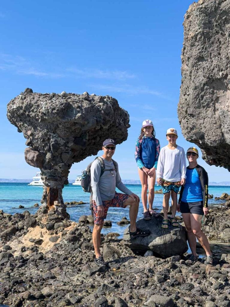The Brewer family, from FamilyCanTravel.com, poses for a picture at the Mushroom Rock near Playa Balandra.