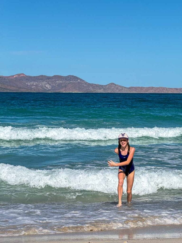 a 12-year old girl on a family vacation in La Paz, Mexico, emerges from the water at Playa el Tecolote.