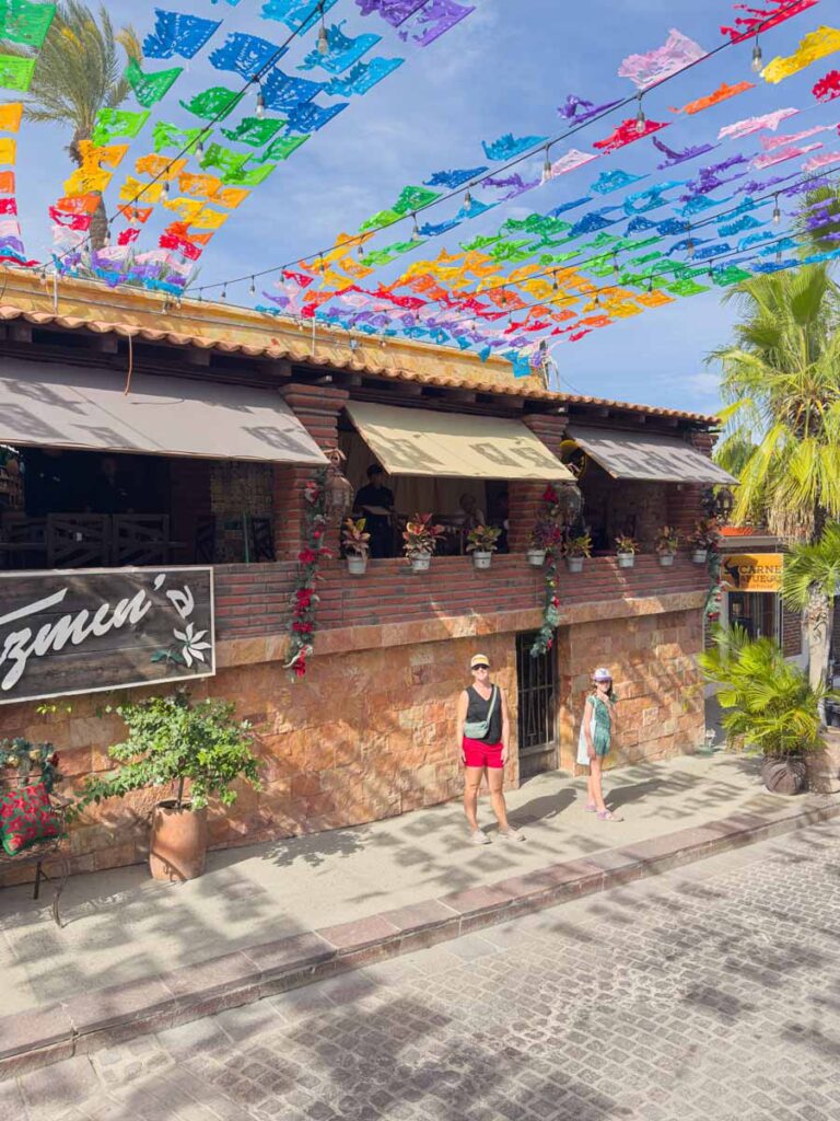 Celine Brewer and her daughter stand under colorful flags in San José del Cabo historic centro district.
