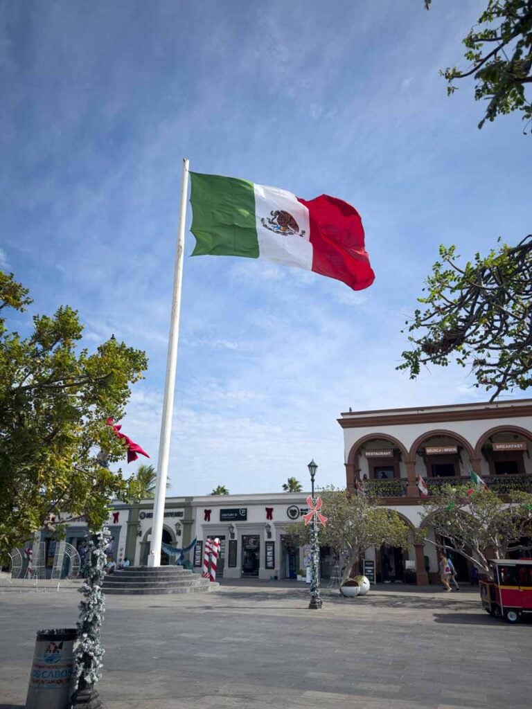a large Mexican flag blows in the wind in Plaza Mijares in San Jose del Cabo, Mexico.