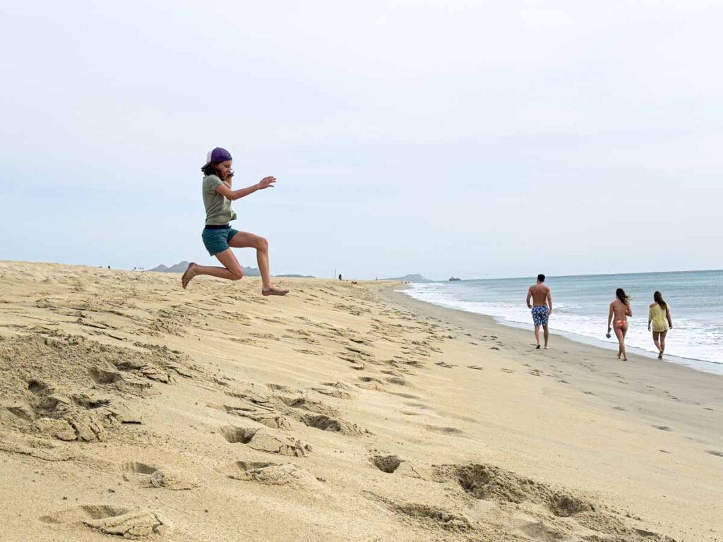 a 12-year old girl tests how far she can jump off a sand bar on Playa Hotelera in San Jose del Cabo, Mexico.