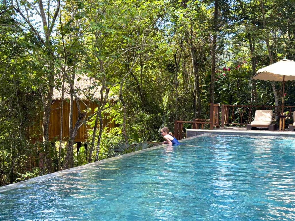 A 12-year old girl looks for tropical birds in the jungle from the infinity swimming pool at the Sweet Songs Lodge in Belize.