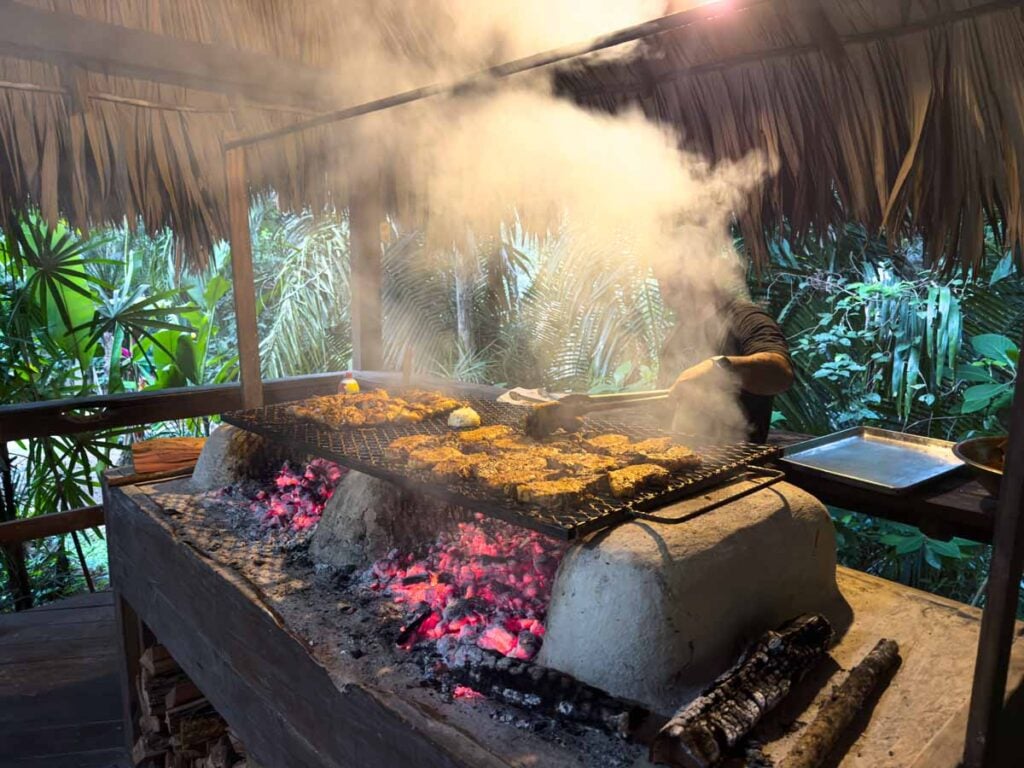 a large barbeque grills meat at the Treehouse Bar at the Sweet Songs Jungle Lodge in San Ignacio, Belize.