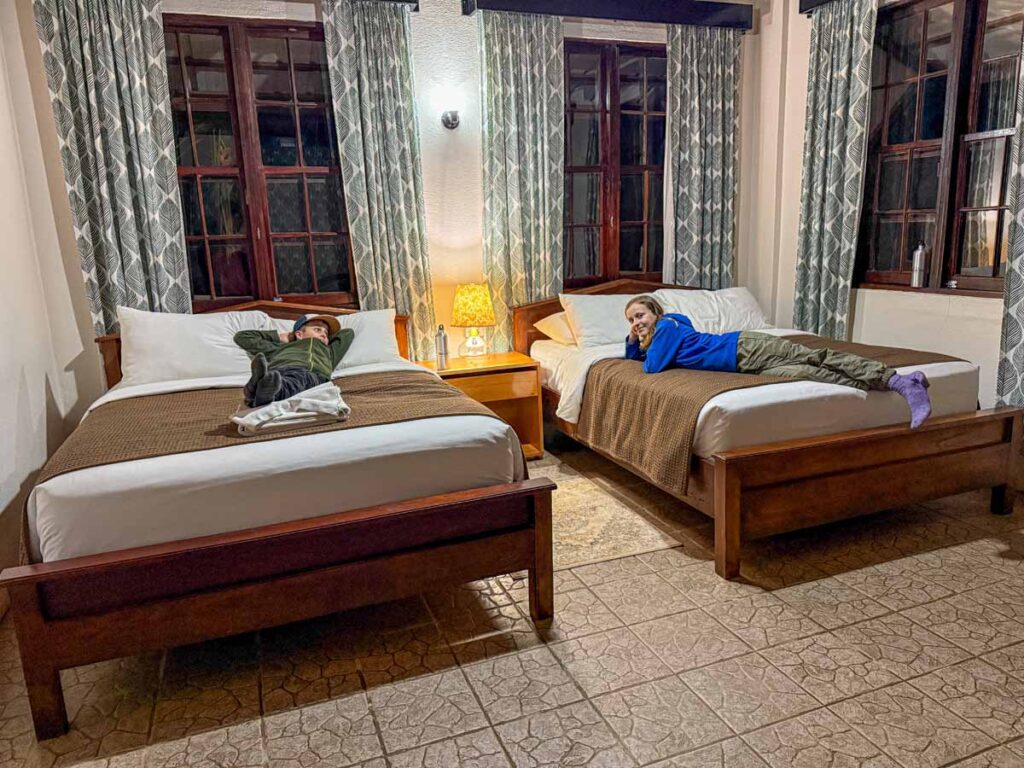 The Brewer kids, from the Family Can Travel blog, relax on their beds in their Double Queen Bungalow room at the Sweet Songs Lodge in San Ignacio, Belize.