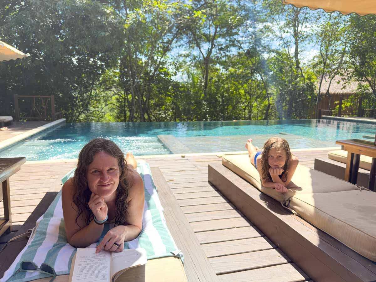 Celine Brewer, owner of FamilyCanTravel.com, sits with her daughter near the beautiful swimming pool at the Sweet Songs Lodge in San Ignacio, Belize.