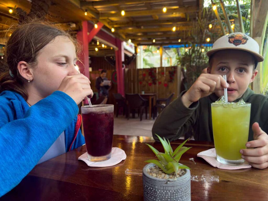 The Brewer kids, from the Family Can Travel blog, enjoy tropical drinks at Tacos La Diosa during a family trip to Ambergris Caye.