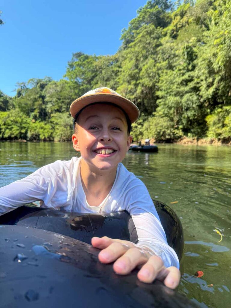 a 10-year old boy is all smiles while tubing on the Macal River during a family stay at the Sweet Songs Jungle Lodge in San Ignacio, Belize.