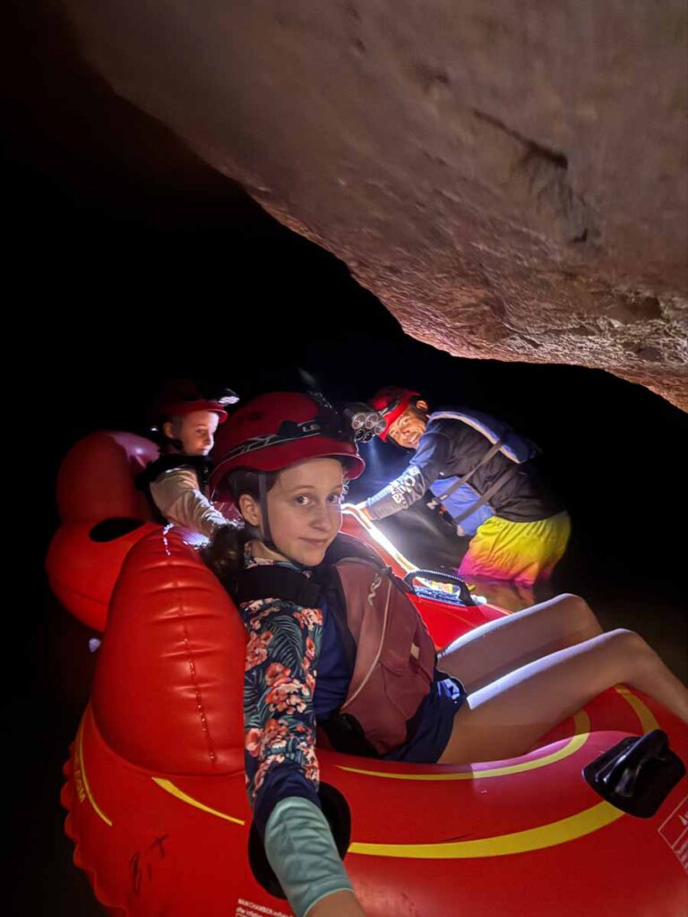 a 12-year old girl from FamilyCanTravel.com, sits on a tube while on a cave tubing tour in Blue Hole National Park in Belize.