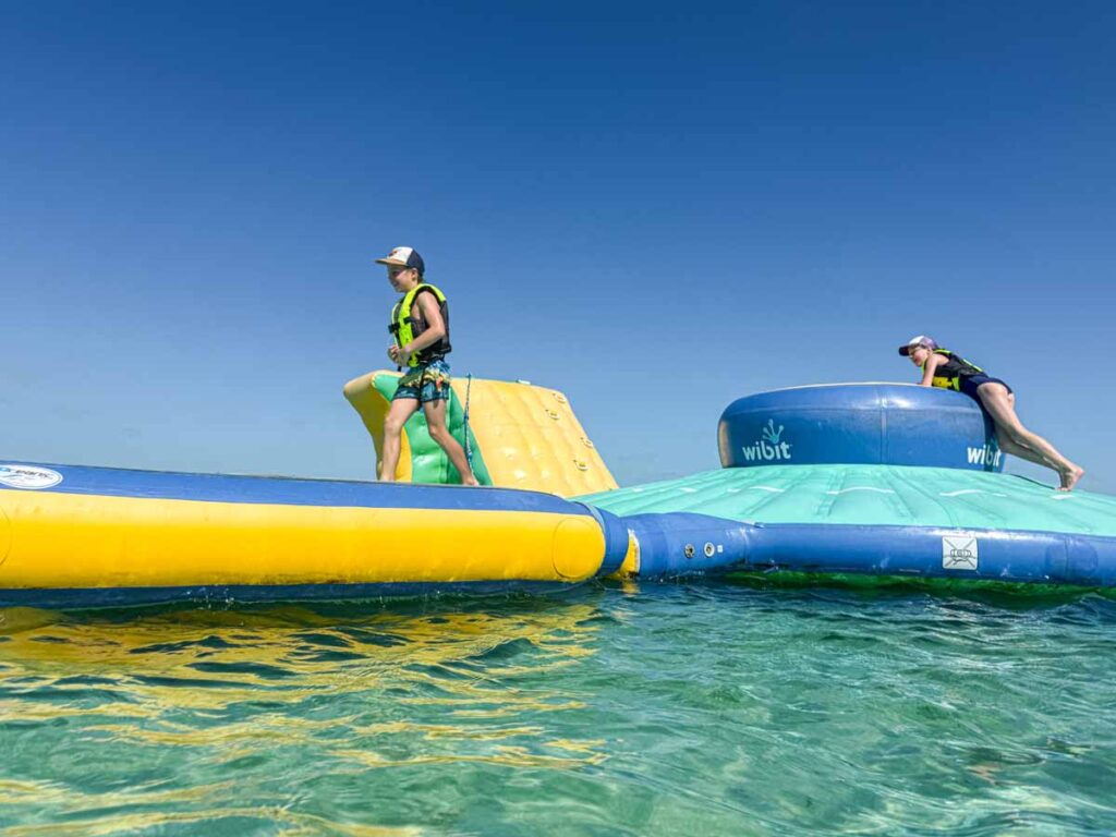 The Brewer kids, from the Family Can Travel blog, play on the Wibit at Secret Beach on Ambergris Caye, Belize.