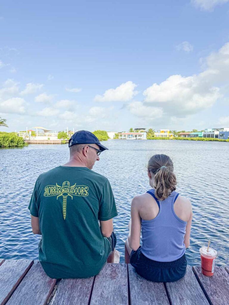 Dan Brewer and his daughter sit on the dock at their lagoon-side vacation rental in Ambergris Caye, Belize.