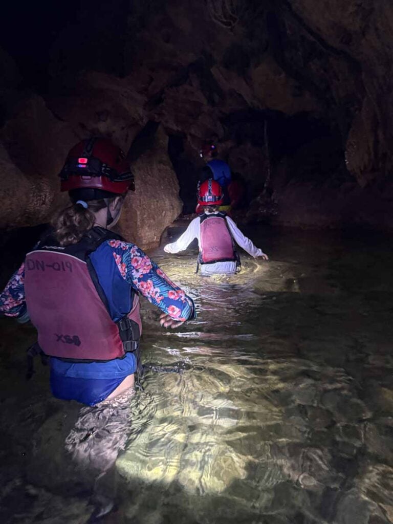 The Brewer kids, from the Family Can Travel blog, walk upstream during a cave tubing tour from San Ignacio, Belize.