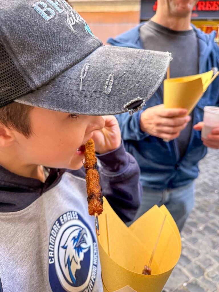 One of the Brewer kids tries a lamb skewer on a family-friendly food tour of Rome.