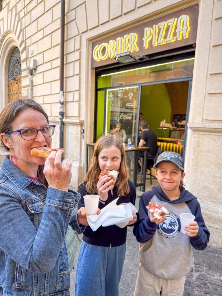 Celine Brewer, owner of Family Can Travel, eats pizza with her kids on a family-friendly food tour in Rome.