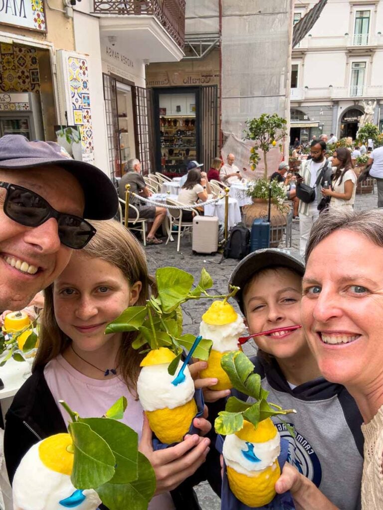 Dan and Celine Brewer, owners of FamilyCanTravel.com, enjoy lemon sorbet with their kids during a day trip to Amalfi, Italy.