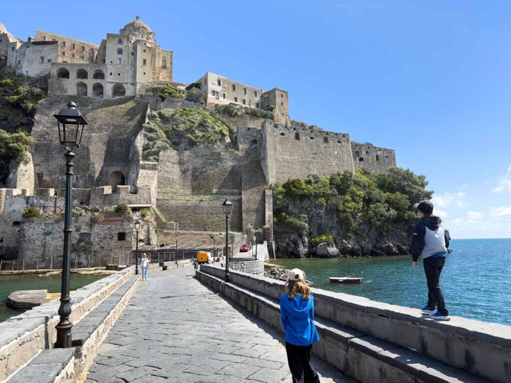 The Brewer kids walk towards the Aragonese Castle during a family trip to Ischia, Italy.