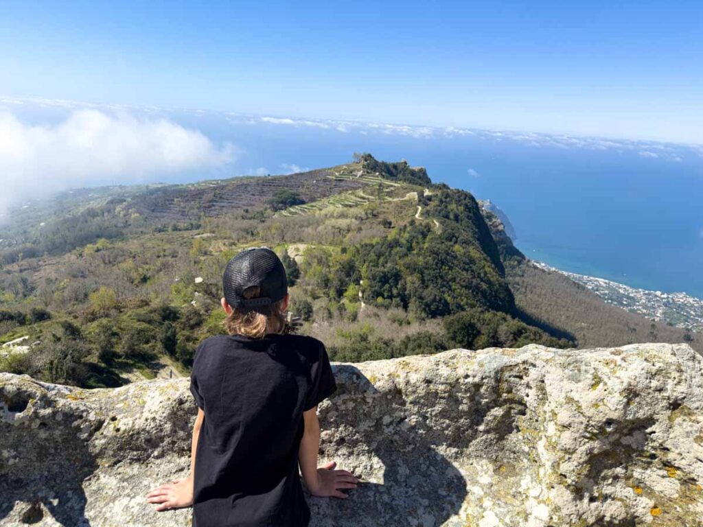 A 10-year old boy enjoys the views of Ischia after a family hike to the summit of Monte Epomeo.