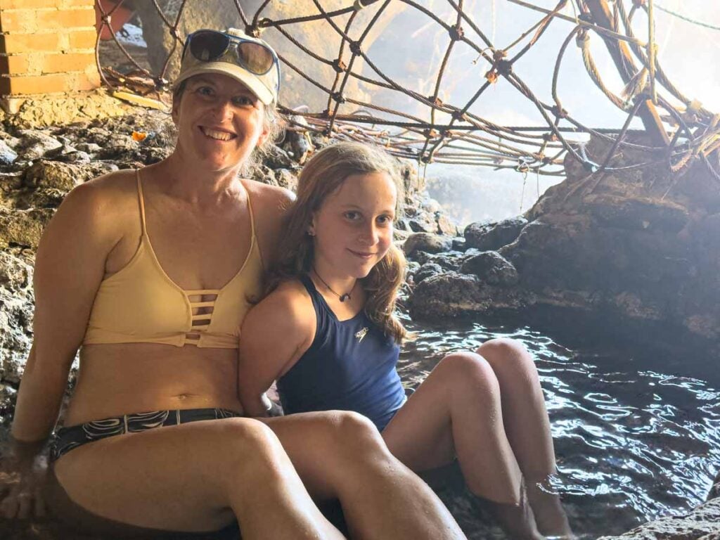 Celine Brewer and her daughter sit in a hot pool inside a cave near Ischia with Kids - Sorgeto Bay on Ischia, Italy.