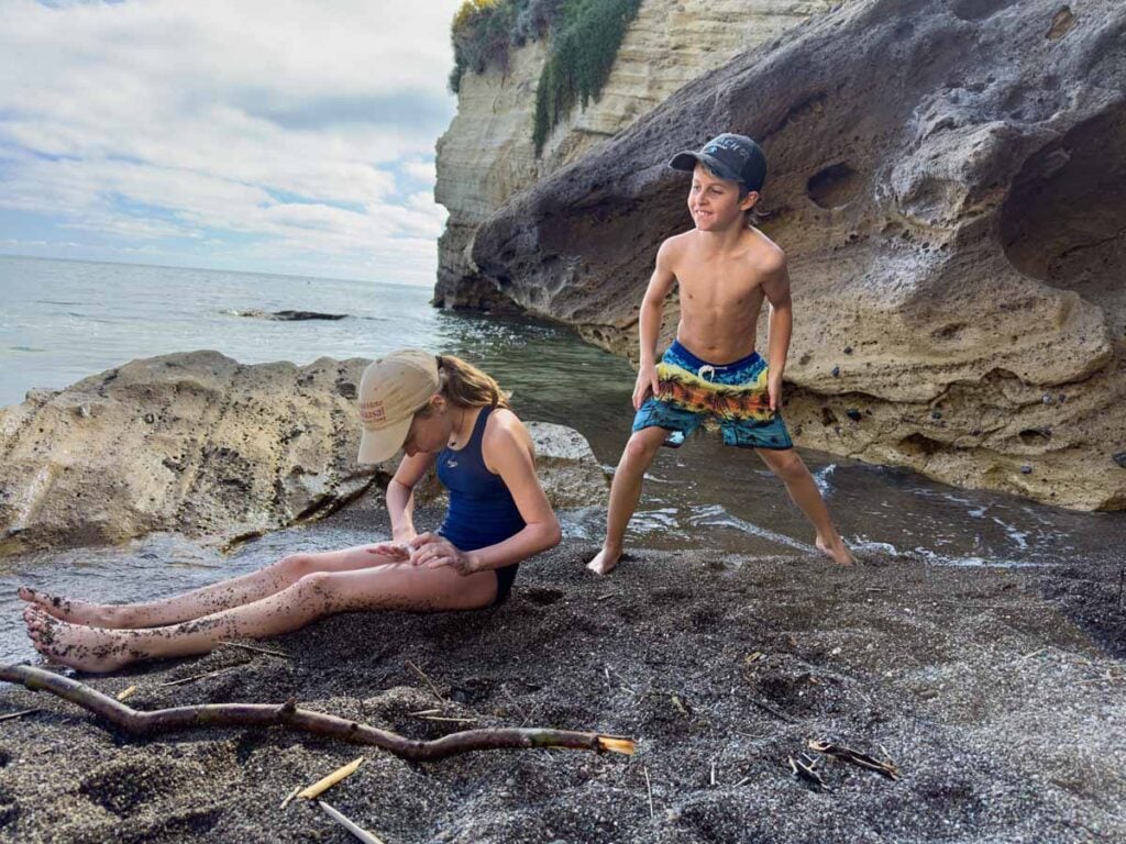 The Brewer kids, from the Family Can Travel blog, enjoy playing in the hot thermal sand at Spiaggia di Cavagrado Thermal Beach.